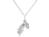A sterling silver pendant featuring an acorn and leaf design, attached to a chain.